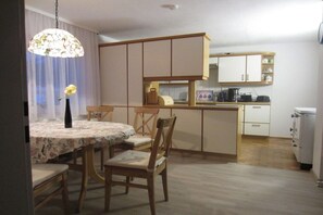 Una cocina compacta con una mesa y sillas, un refrigerador pequeño y un microondas.
