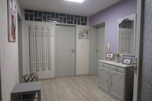 A room with a door, a coat rack, a cabinet, and a mirror. - Holiday apartment with 1 bedroom (Neuried)