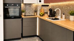 Cozinha moderna com forno Bosch, bancada de madeira e pia embutida.