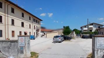A residential street with parked cars and buildings on either side.