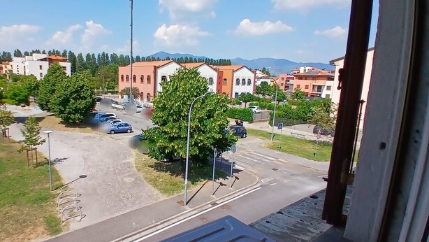 Asuinalue, jossa on katu, parkkeerattuja autoja ja rakennuksia.