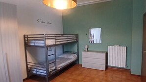 Huoneessa on kerrossängyt, lipasto, peili ja patteri.
