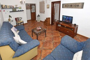 A living room with a sofa set, a coffee table, a television, and a bookshelf. - Cozy house with garden and sea views (Tazacorte)