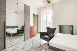A hotel room with a bed, a chair, a dresser, a mirror, and a radiator. - Holiday Home - Matino (Matino)