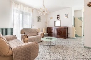 A living room with a sofa, armchair, and a glass coffee table. - Holiday Home - Matino (Matino)