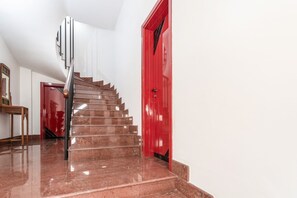 A staircase with a polished marble floor leading to a red door. - Holiday Home - Matino (Matino)