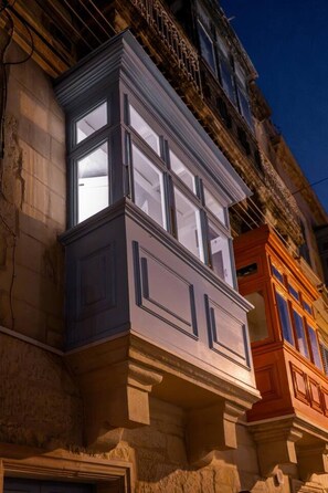 Un edificio ad angolo con una finestra a bovindo e un portone da garage in vista.