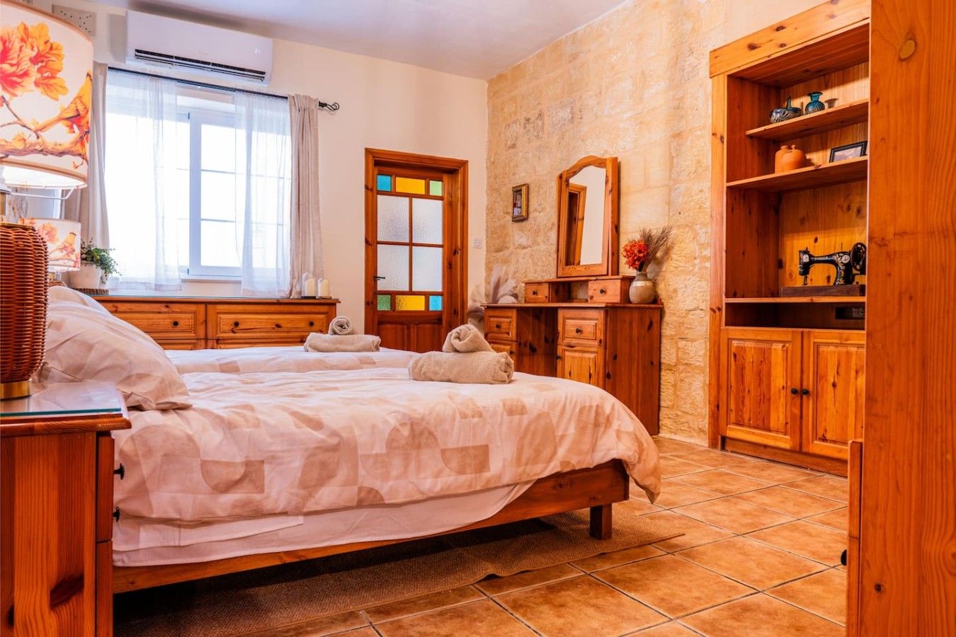 Una camera da letto con un letto grande, un'armadio in legno e una finestra con tende.