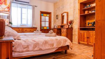 Una camera da letto con un letto grande, un'armadio in legno e una finestra con tende.