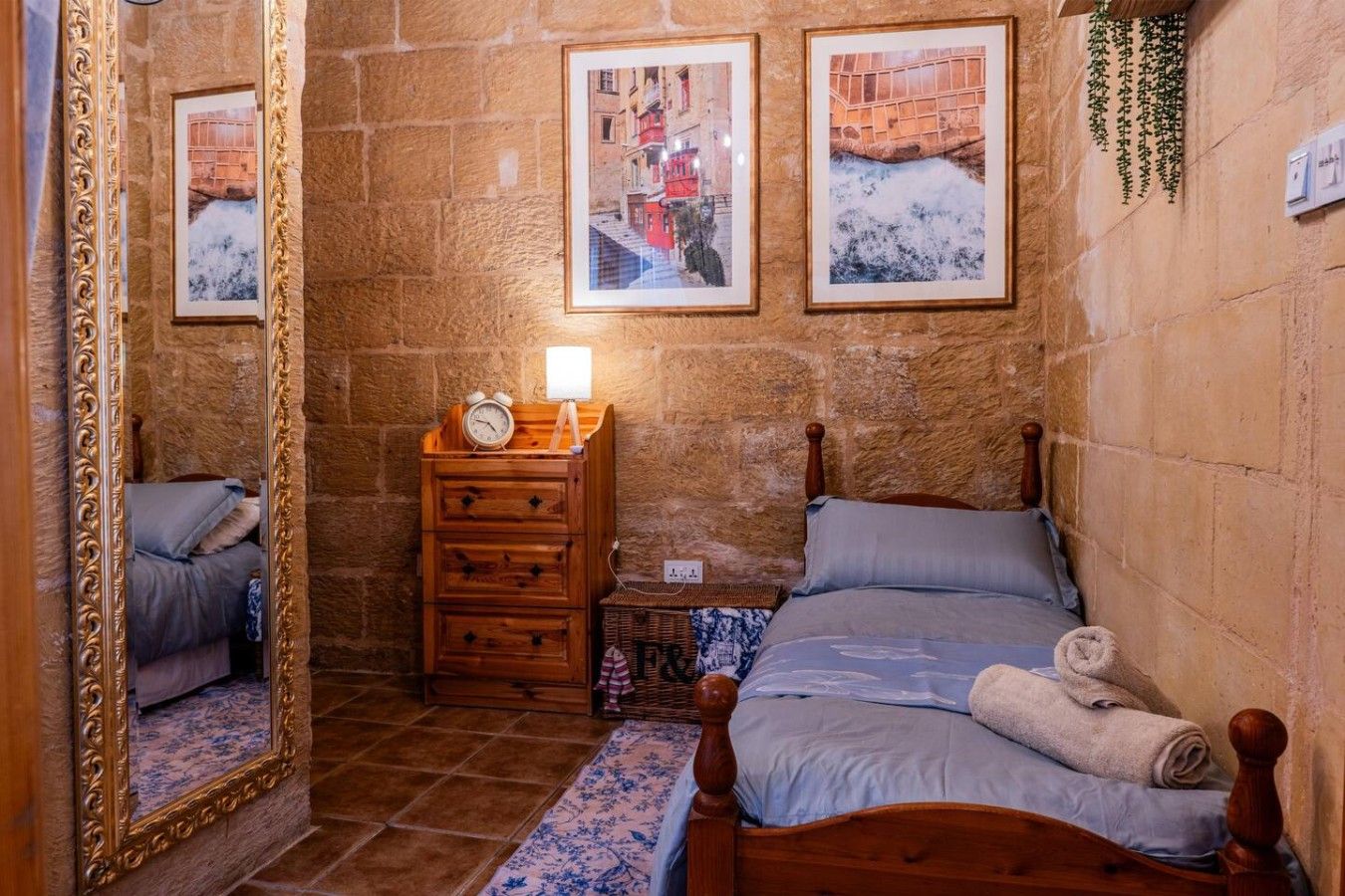 Une pièce comprenant un lit, une commode, un miroir et une horloge fixée au mur.
