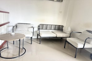 Un'area relax con un tavolino rotondo, due poltrone e un divano.