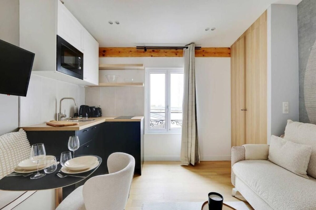 Un espacio habitable compacto con kitchenette, comedor y zona de estar.