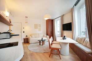 Un espace de vie moderne comprenant un canapé, une table à manger et un coin cuisine.