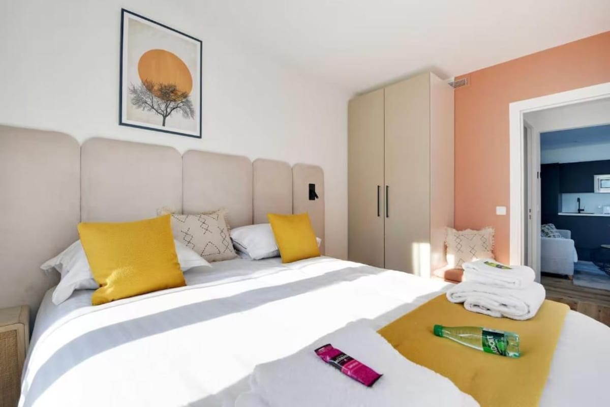 Habitación de hotel con cama, armario y un cuadro en la pared.
