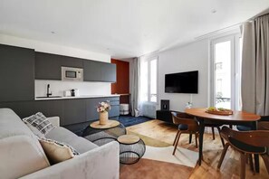 Un espacio moderno para vivir con sofá, mesa de comedor y zona de cocina.