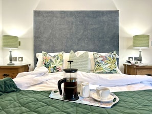 A neatly made bed with a green quilt, a coffee pot, two cups, and a tray with a map. - Spacious and secluded countryside escape - walking distance to Mawgan Porth Beach (Mawgan Porth)