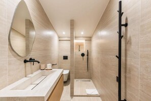 A modern bathroom with a large mirror, a bathtub, a shower, and a toilet. - Opéra - Elégant appartement - Haystia (Paris)