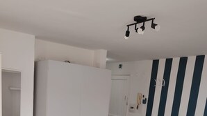 Quarto com cama, guarda-roupa e parede listrada.