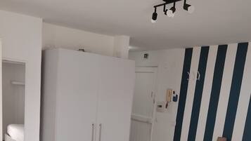 Ein Schlafzimmer mit einem Bett, einem Kleiderschrank und einer Wand mit Streifen.
