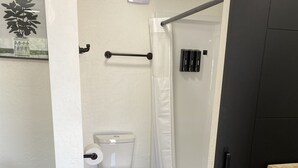 Ein Badezimmer mit Toilette, Dusche und Handtuchhalter.