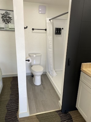 Ein Badezimmer mit Toilette, Dusche und Handtuchhalter.