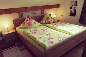 A room with a bed, two nightstands, a lamp, and a wall-mounted picture. - Holiday apartment with 1 bedroom (Bernau am Chiemsee)