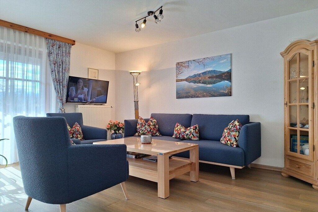 A living room with a blue sofa, a coffee table, and a television.