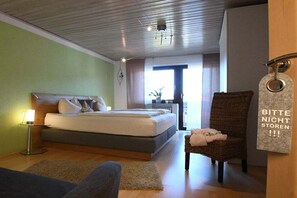 A bedroom with a bed, a chair, a bedside table, and a wall-mounted sign. - Holiday apartment with 3 bedrooms (Zwiesel)