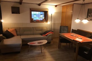 A cozy living room with a sofa, a small round table, and a dining table with chairs. - Heather beetle - "Holiday home hedgehog" (Kirchlinteln-Bendingbostel)