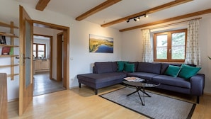 Uma sala de estar moderna com um sofá seccional, uma mesa de centro e um quadro na parede.