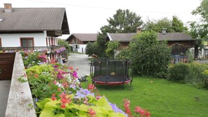 Een woonwijk met huizen, een trampoline en een tuin met bloemen.