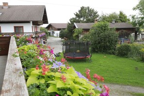 A residential area with houses, a trampoline, and a garden with flowers. - Holiday apartment with 1 bedroom (Übersee)