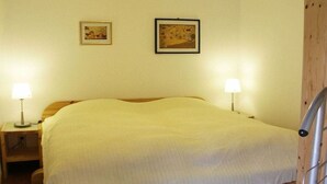 A room with a bed, two bedside lamps, and two framed pictures on the wall. - Holiday apartment with 1 bedroom (Gummersbach - Lieberhausen)