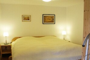 A room with a bed, two bedside lamps, and two framed pictures on the wall. - Holiday apartment with 1 bedroom (Gummersbach - Lieberhausen)