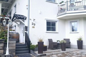 A white building with a number 29 sign, outdoor seating, and a sign for 'Gästeparkplatz.' - Holiday apartment with 1 bedroom (56332 Burgen)
