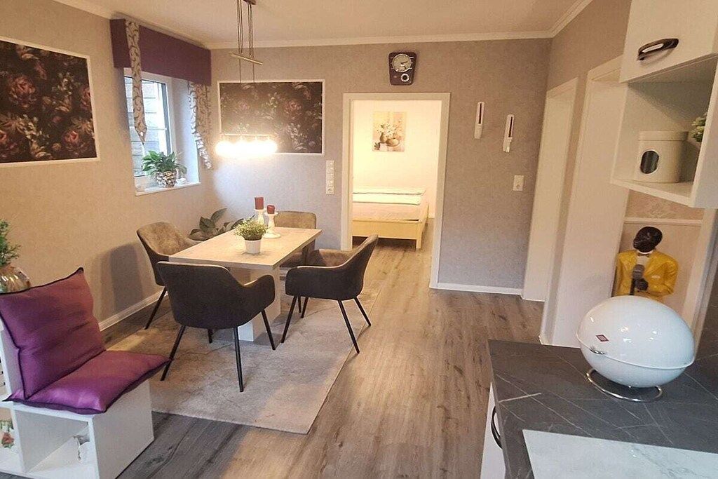 Un espacio habitable compacto con comedor, una kitchenette pequeña y un dormitorio.
