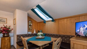 A cozy dining area with a wooden table, chairs, and a bench. - Karwendele Echo - Edelweiss (Mittenwald)