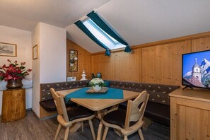 A cozy dining area with a wooden table, chairs, and a bench. - Karwendele Echo - Edelweiss (Mittenwald)