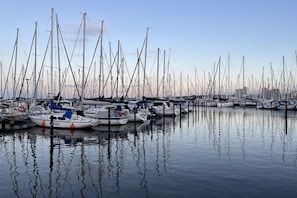A marina with multiple boats docked, calm water, and a clear sky. - Holiday apartment with 2 bedrooms (Heiligenhafen)