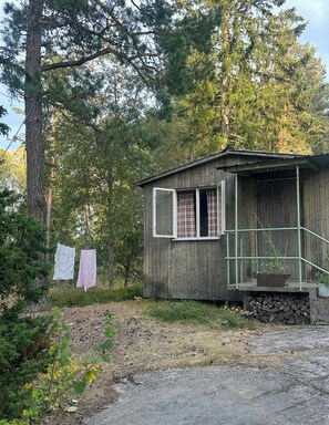 Eine kleine Holzhütte mit Veranda und Steinuntergrund.
