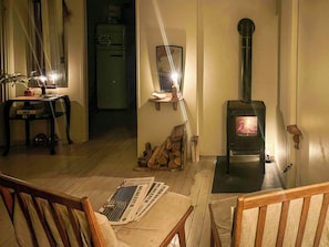 Un salon chaleureux avec une table en bois, des chaises, une cheminée et un miroir au mur.