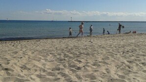 En sandstrand med klar himmel och stilla hav.