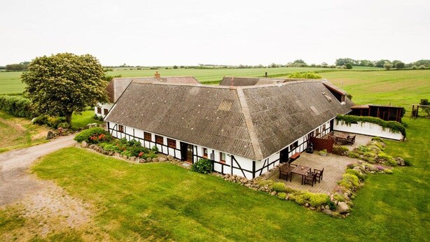 A traditional thatched-roof house with a garden and a small pond. - Nydamsgaard "hus lille rede" (Faaborg \/ Bojden)