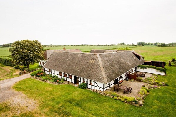 A traditional thatched-roof house with a garden and a small pond. - Nydamsgaard "hus lille rede" (Faaborg \/ Bojden)