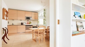 Eine moderne Küche mit Holzausstattung, einer Mikrowelle und einem Essbereich mit Tisch und Stühlen.