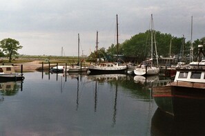 A marina with several boats docked, calm water, and a grassy area in the background. - Small holiday apartment Pappelhof (Fehmarn)