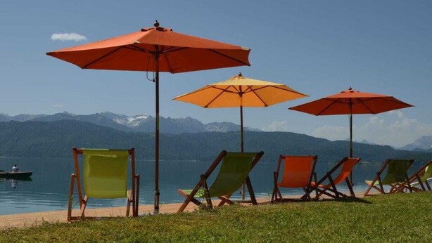 Vista de un lago con sillas de playa y sombrillas.