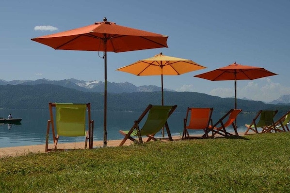 A lakeside view with beach chairs and umbrellas. - No. 3 - The Lake House (Walchensee)