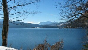 Un paisaje nevado con una vista despejada de un lago y montañas lejanas.