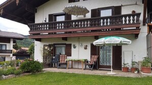 Um edifício com varanda, mesas ao ar livre e uma placa que indica um jardim de cerveja.